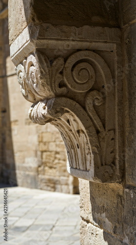 Historic carved limestone architectural corbel on ancient palazzo facade in sunlight