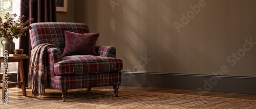 Cozy armchair upholstered in burgundy and blue plaid fabric, featuring a plush throw pillow and a textured blanket draped over the arm, set in a warm, inviting room with natural light and wooden