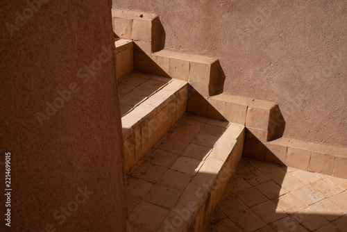 Angular sunlight and shadows across warm tiled steps