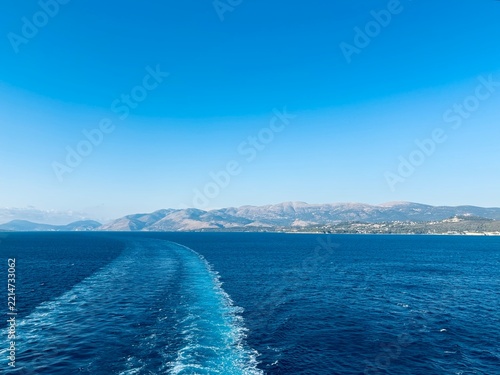 Heckwelle hinter einem Kreuzfahrtschiff bei der Ausfahrt aus Argostoli, Kefalonia, Griechenland, 