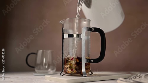 Brewing warm herbal tea with electric kettle, cozy autumnal scene