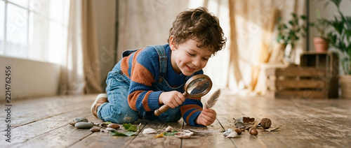 Curious boy exploring nature objects with magnifying glass early childhood discovery learning and outdoor hobby