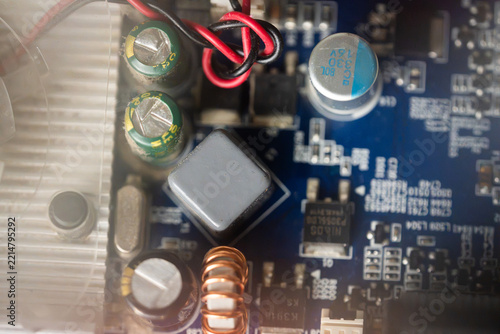 Horizontal Top-Down View of Microchip Components and Capacitors on Blue Circuit Board, Close Up Overhead View of Electronic Motherboard Components with Copper Coil