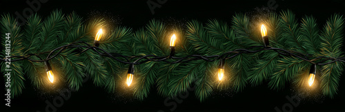 Pine garland with large warm Christmas bulbs on dark background
