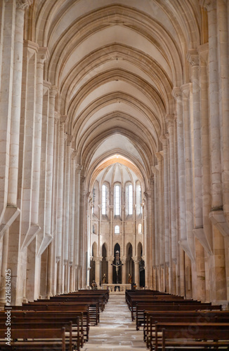 Central nave of Alcobaça Monastery with Gothic vaulted ceiling and stone columns. 