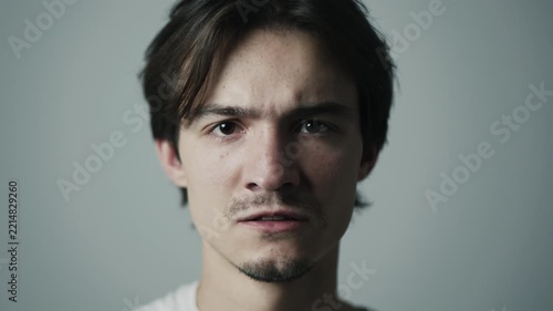 Man's face showing anger and emotional distress with frowning expression