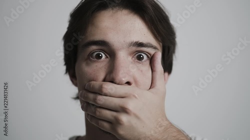 Man showing shock and fear with wide eyes and hand covering mouth
