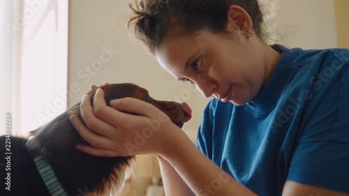 Woman affectionately cuddling her adorable little dog
