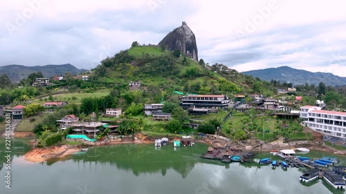 Guatapé with Piedra del Peñol Rising Above the Reservoir in Antioquia, Colombia. Establishing Shot. Aerial View.
