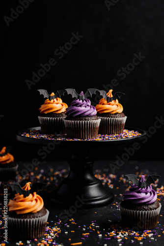 Halloween chocolate cupcakes with orange and purple frosting and bat toppers