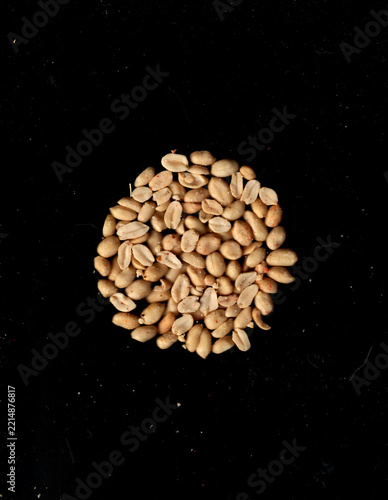 peeled peanuts over black back. nuts centered aerial view. peanuts for ingredients