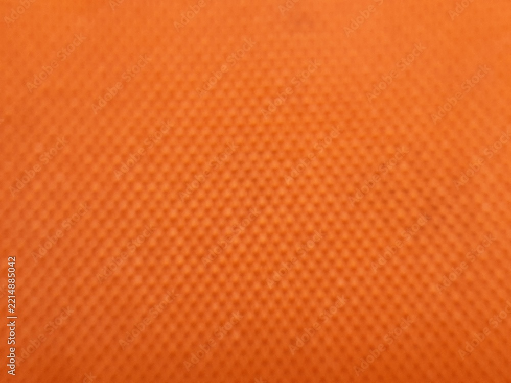 Obraz premium blurred orange fabric texture background with subtle dot mesh pattern