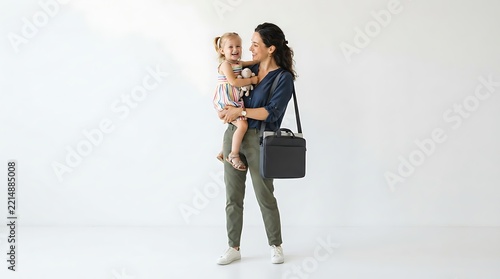 A smiling mother carries her young daughter while wearing a professional laptop shoulder bag