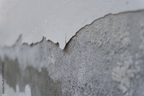 Selective focus on peeling paint and rough concrete wall texture