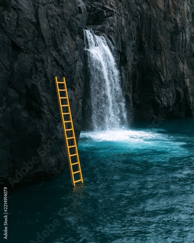 Yellow ladder beside a waterfall in a rocky gorge