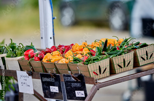 Baskets of fresh peppers for sale at an outdoor farmer's market