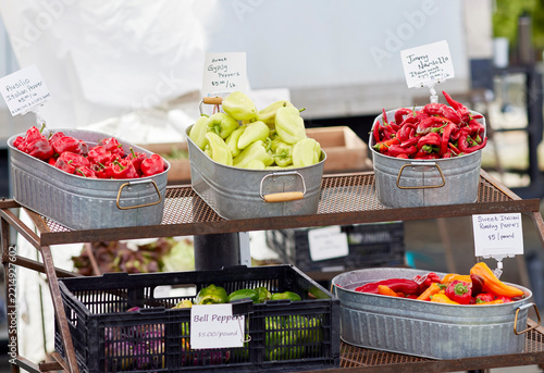 Baskets of fresh peppers for sale at an outdoor farmer's market
