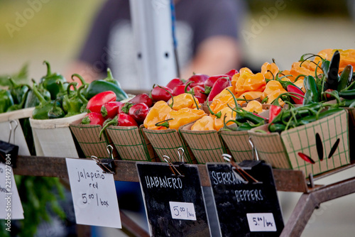 Baskets of fresh peppers for sale at an outdoor farmer's market
