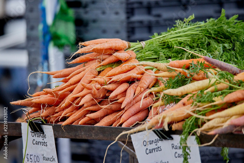 Bushels of Carrots for sale at an outdoor farmer's market
