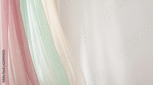 Flowing sheer chiffon in dusty pink mint and cream beside a soft wall