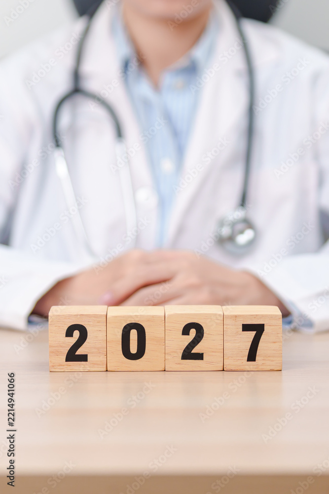 Fototapeta premium Happy New Year 2027 with Stethoscope of doctor and heart shape on table. health care, Insurance, Wellness and medical concepts