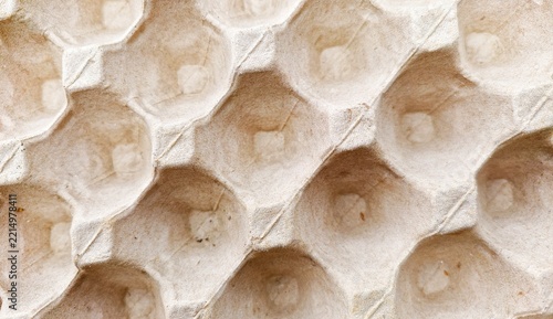 A close-up, overhead view of an empty, recyclable cardboard egg carton. Shock-absorbing packaging designed to protect eggs.