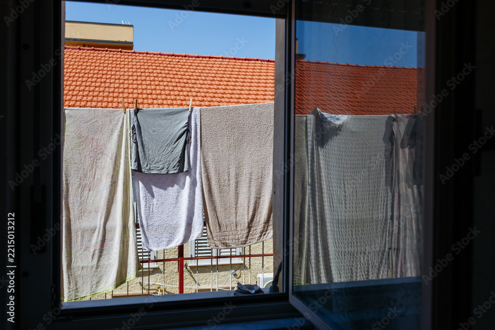 Fototapeta premium Towels Drying on Clothesline Outside Window, Mediterranean Home with Terracotta Roof
