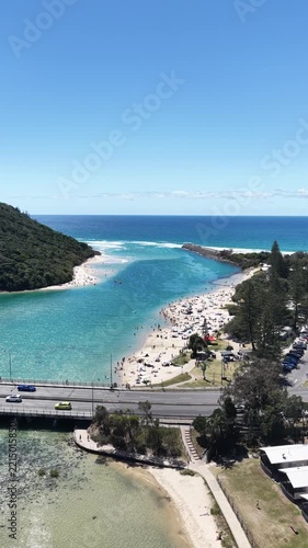Aerial drone footage of the busy creek beach at Tallebudgera on a summer day, Gold Coast, Queensland Australia - vertical video