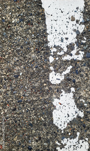 Weathered white road line paint on rough asphalt surface texture photo