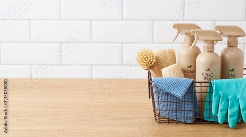 Eco friendly cleaning products in wire basket on wooden countertop