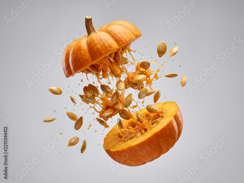 Ripe Orange Pumpkin Exploding In Halves With Seeds Flying Out
