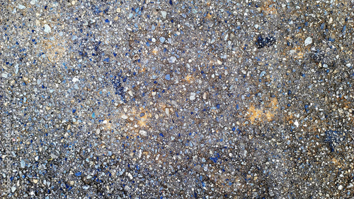 Rough asphalt and aggregate road surface texture with subtle rust stains photo