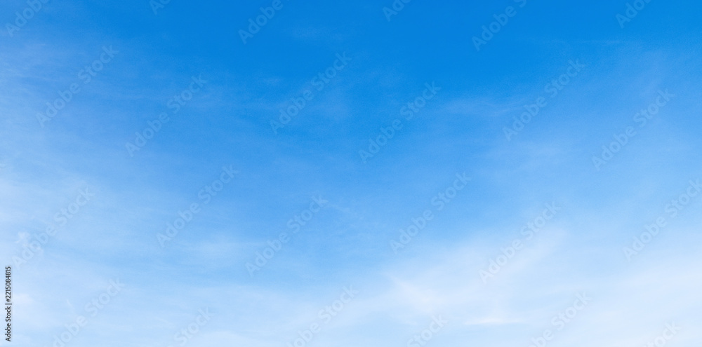 Fototapeta premium Clear blue sky with soft, wispy clouds drifting