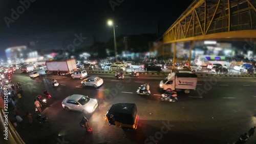Urban Indian Highway Traffic at Night with Streetlights, Delivery Trucks, and Commuters.