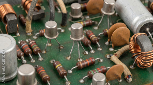 Vintage electronic circuit board with transistors, resistors, and copper coils. 