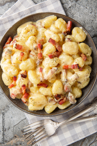 gnocchi carbonara a comforting twist on the classic pasta dish closeup on the plate on the table. Vertical top view from above