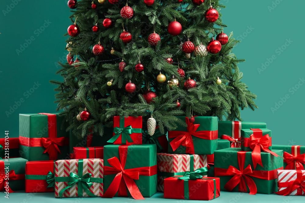 Fototapeta premium Christmas tree with many gifts on green background