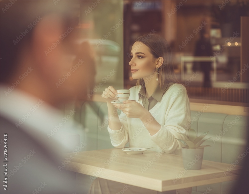Fototapeta premium Candid Coffee Moment Seen Through Urban Cafe Window