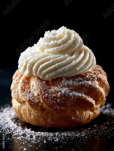 Delicious Cream Puff Dessert with Powdered Sugar on Black Background