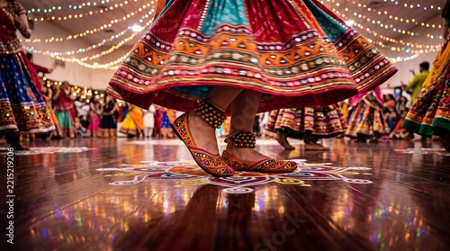 Low angle shot of dancer's feet in embroidered mojari shoes with ankle bells mid-step during Garba circle on reflective wood floor