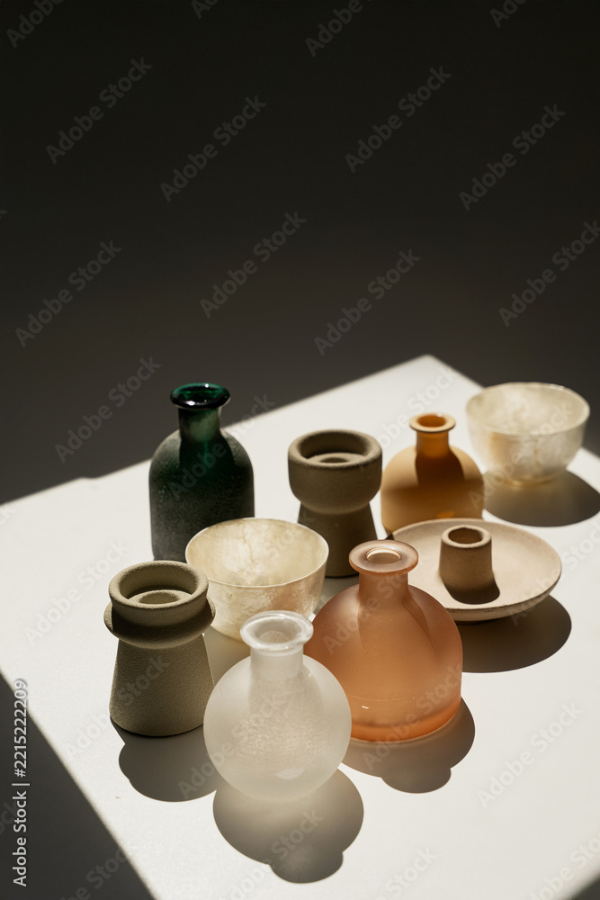 Obraz premium Minimalist Composition Of Vases On White Platform In Deep Shadow