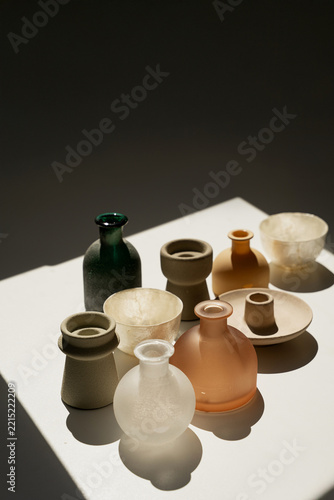 Minimalist Composition Of Vases On White Platform In Deep Shadow