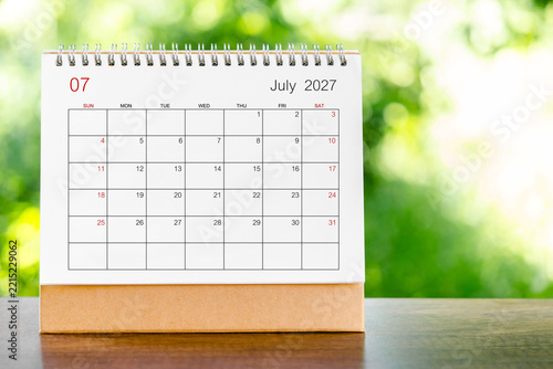 July 2027 Calendar desk for organizer to plan and reminder on wooden table.