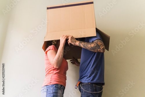 Couple with heads together in cardboard box at new home