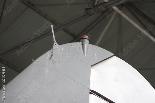 Close up of vintage airplane tail fin and vertical stabilizer inside a hangar