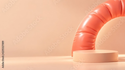 Coral inflatable arch behind a peach display podium on a warm studio backdrop