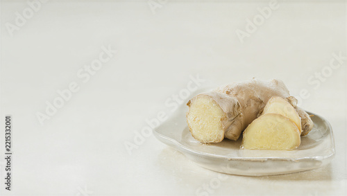 Fresh ginger root pieces on a cream ceramic dish