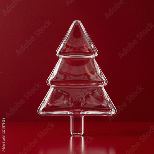 Minimalist clear glass Christmas tree decoration on an elegant deep red background
