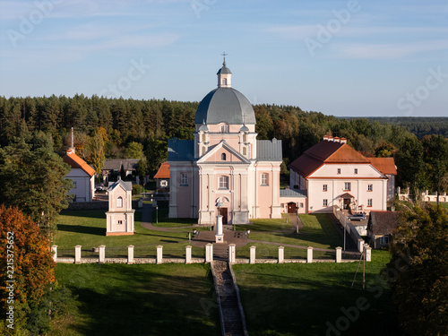 Aerial view of the Liskiava Monastery Ensemble, a historic church with a dome and monastic buildings set amidst lawns and autumn trees in Liskiava, Alytaus apskritis, Lithuania.