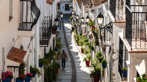 MIJAS, MÁLAGA, SPAIN – Man walking along a traditional whitewashed street in Mijas Pueblo, Spain.